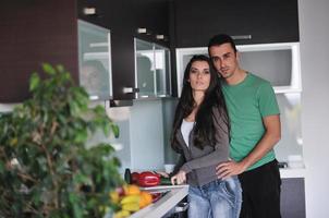 jovem casal se diverte na cozinha moderna foto