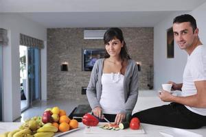 jovem casal se diverte na cozinha moderna foto