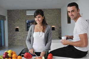 jovem casal se diverte na cozinha moderna foto