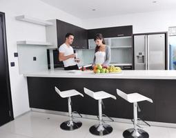 jovem casal se diverte na cozinha moderna foto