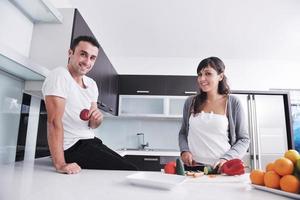 jovem casal se diverte na cozinha moderna foto