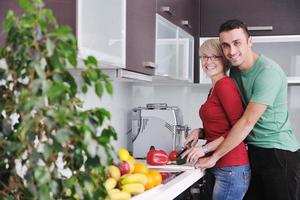 jovem casal se diverte na cozinha moderna foto