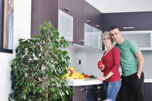 jovem casal se diverte na cozinha moderna foto