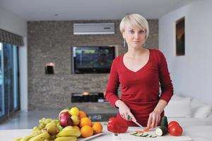 feliz linda mulher loira preparar comida na cozinha foto