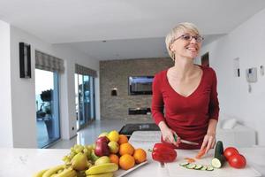 feliz linda mulher loira preparar comida na cozinha foto