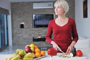 feliz linda mulher loira preparar comida na cozinha foto
