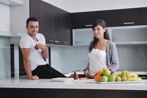 jovem casal se diverte na cozinha moderna foto