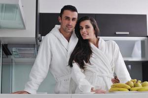 jovem casal se diverte na cozinha moderna foto