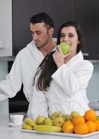 jovem casal se diverte na cozinha moderna foto