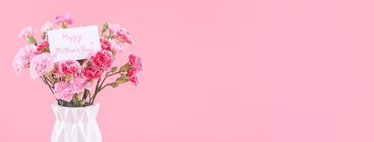 dia das mães, conceito de design de presente de feriado do dia dos namorados, buquê de flores de cravo rosa com caixa embrulhada isolada em fundo rosa claro, espaço de cópia. foto
