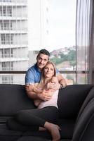 jovem casal bonito abraçando no sofá foto