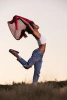 garota negra dança ao ar livre em um prado foto