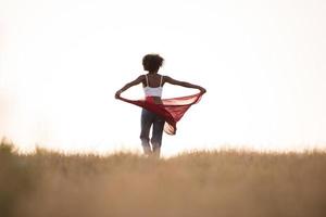 garota negra dança ao ar livre em um prado foto