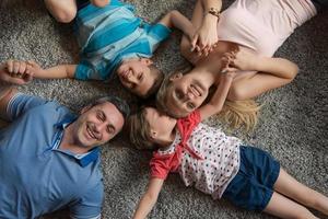 família feliz deitada no chão foto