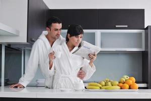 jovem casal se diverte na cozinha moderna foto