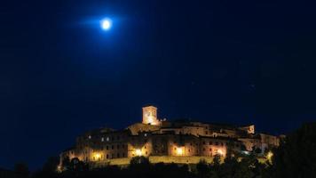 noite panorâmica com a lua da vila medieval de anghiari na toscana - itália
