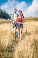 casal de desportistas durante o exercício de caminhada nórdica foto