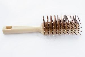escova de cabelo com cabelo perdido no fundo branco foto