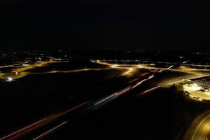 vista aérea noturna das autoestradas britânicas com estradas iluminadas e tráfego. imagens de rodovias tiradas com a câmera do drone sobre milton keynes e rodovias da inglaterra à noite escura foto