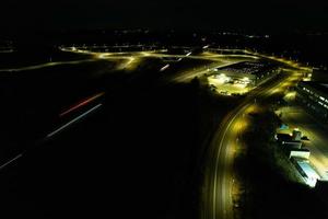 vista aérea noturna das autoestradas britânicas com estradas iluminadas e tráfego. imagens de rodovias tiradas com a câmera do drone sobre milton keynes e rodovias da inglaterra à noite escura foto