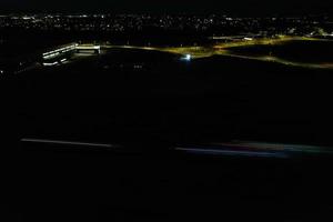 vista aérea noturna das autoestradas britânicas com estradas iluminadas e tráfego. imagens de rodovias tiradas com a câmera do drone sobre milton keynes e rodovias da inglaterra à noite escura foto