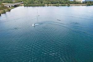 belas imagens da câmera do drone aéreo de willen lake and park, localizado em milton keynes, inglaterra. as pessoas estão desfrutando no lago em um dia quente e ensolarado de verão foto