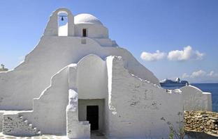 igreja de mykonos com navio de cruzeiro ao fundo foto