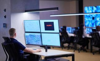 jovem operador masculino trabalhando em uma sala de controle do sistema de dados de segurança foto