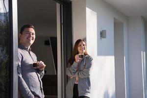 casal desfrutando na porta de sua casa de luxo foto