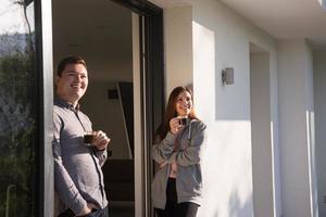 casal desfrutando na porta de sua casa de luxo foto