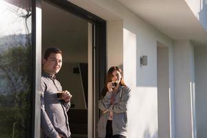 casal desfrutando na porta de sua casa de luxo foto