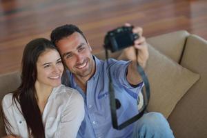 casal brincando com câmera digital em casa foto