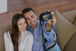 casal brincando com câmera digital em casa foto