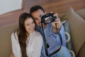 casal brincando com câmera digital em casa foto