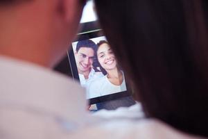 casal em casa moderna usando computador tablet foto