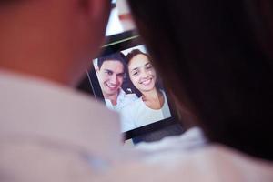 casal em casa moderna usando computador tablet foto