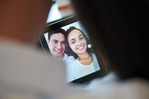 casal em casa moderna usando computador tablet foto