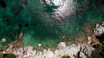 vistas aéreas de drones sobre um litoral rochoso, águas cristalinas do mar egeu, praias turísticas e muita vegetação na ilha de skopelos, grécia. uma visão típica de muitas ilhas gregas semelhantes. foto