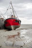 barcos de pescadores presos na praia no período de maré baixa. foto