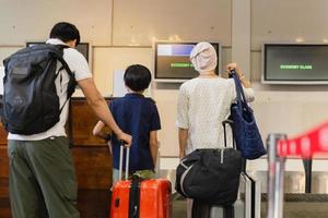 família em pé com bagagem check-in no aeroporto. foto