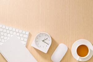 mesa de escritório branca moderna com teclado, mouse, notebook, relógio e xícara de café. vista superior com copiar e colar. maquete de conceito de negócios e estratégia. foto