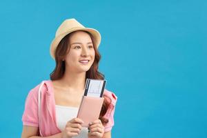 retrato de jovem mulher asiática segurando o passaporte e sorriso. pessoas felizes e conceito de viagens. foto