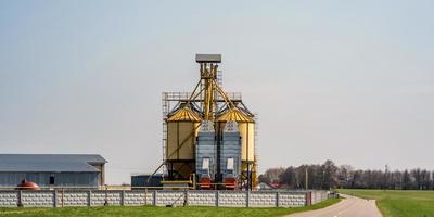 elevador de celeiro moderno. silos de prata em agro-processamento e planta de fabricação para processamento de secagem, limpeza e armazenamento de produtos agrícolas, farinhas, cereais e grãos. linha de limpeza de sementes foto