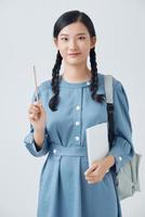 alegre jovem adolescente asiática com mochila tem uma ideia e segurando o notebook isolado em um fundo branco foto