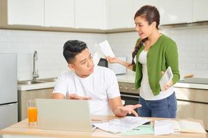 casal jovem irritado discutindo por suas muitas dívidas em casa. conceito de problemas familiares financeiros. foto