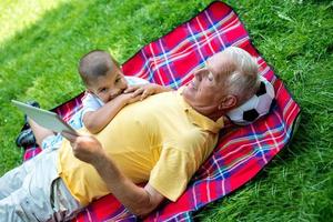 avô e filho no parque usando tablet foto