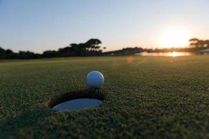 bola de golfe na borda do buraco foto