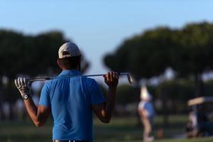 golfista de volta ao campo olhando para o buraco à distância foto