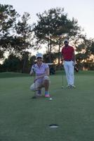 casal no campo de golfe ao pôr do sol foto