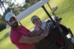 casal de buggy no campo de golfe foto